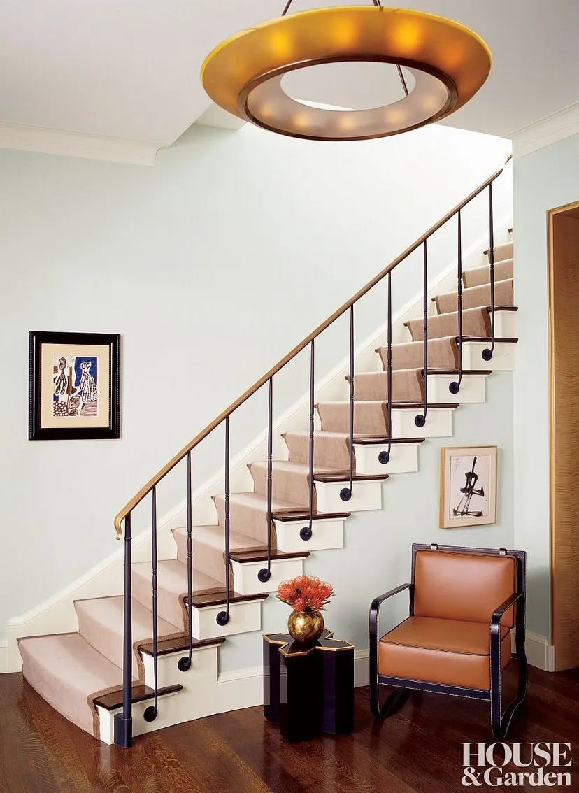 straight stair ,The entry of a Manhattan apartment features a saddle-stitched armchair by Jacques Adnet, circa 1950.